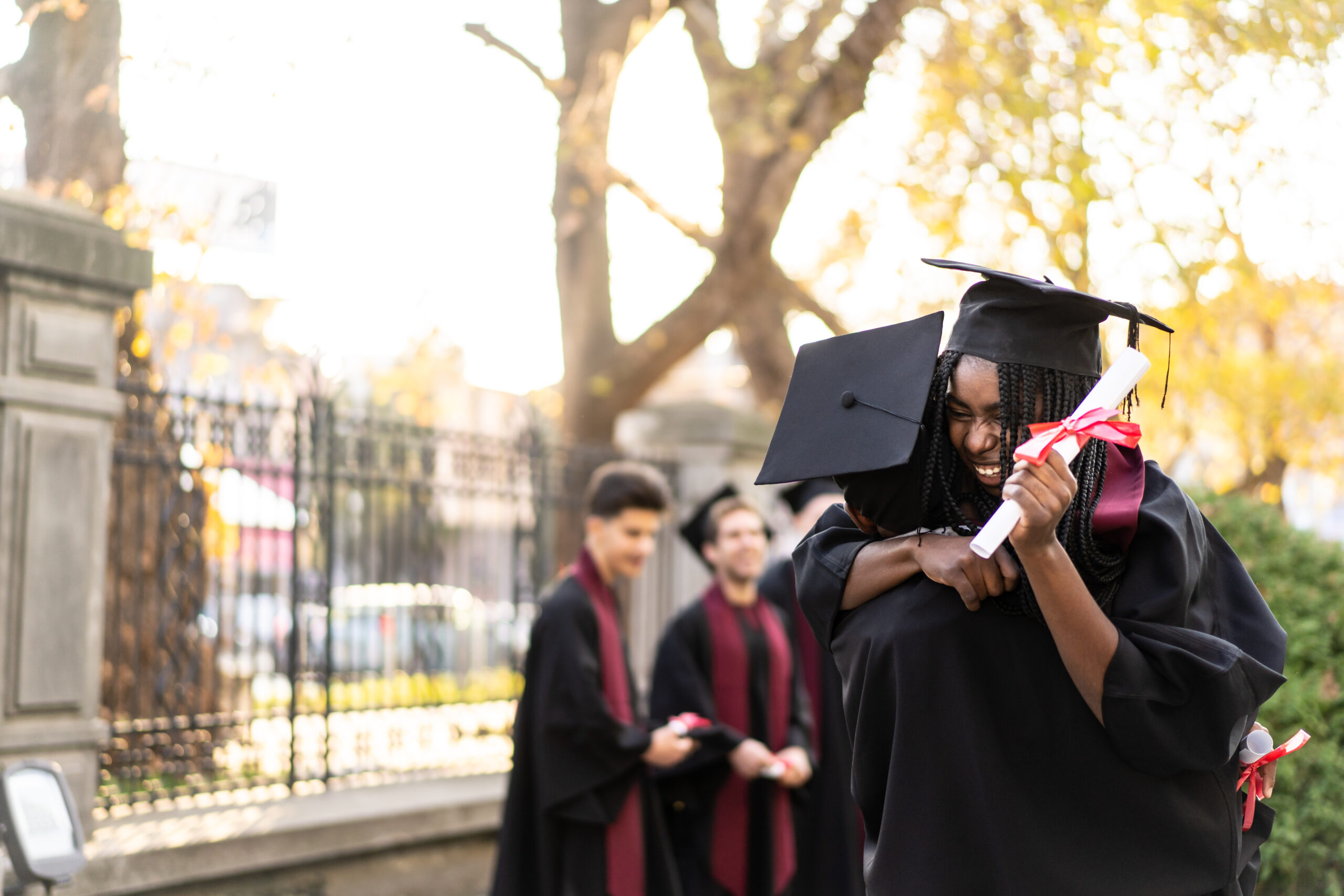 Shot of two happy young students hugging each other on graduation day